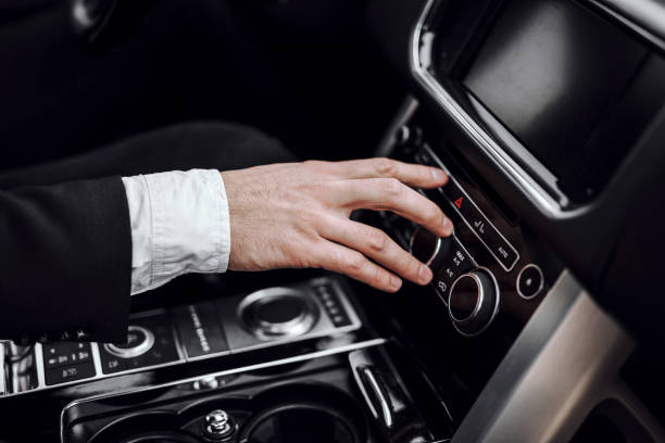 istock Businessman changing radio station while driving automobile 1239637236