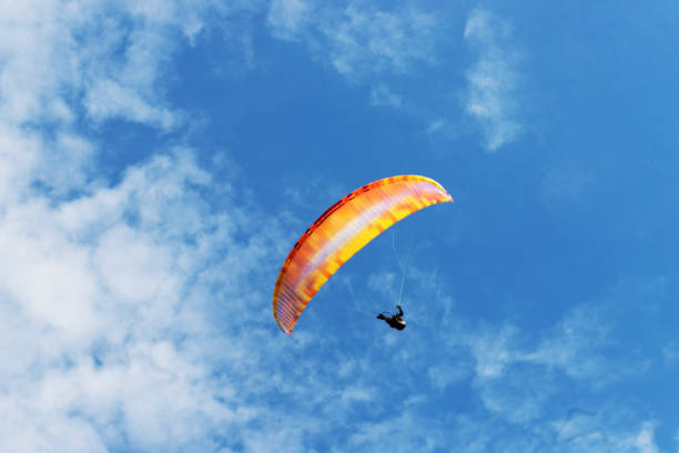 istock paraglider in a blue cloudy sky 1239642588