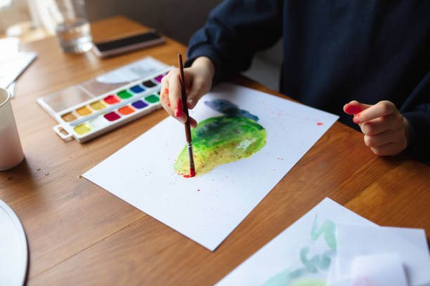 istock Girl drawing with paints and pencils at home, watching teacher's tutorial on laptop. Digitalization, remote education 1239645774