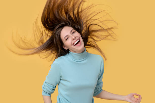 istock Long-haired girl bouncing while playing an air guitar. 1239665544