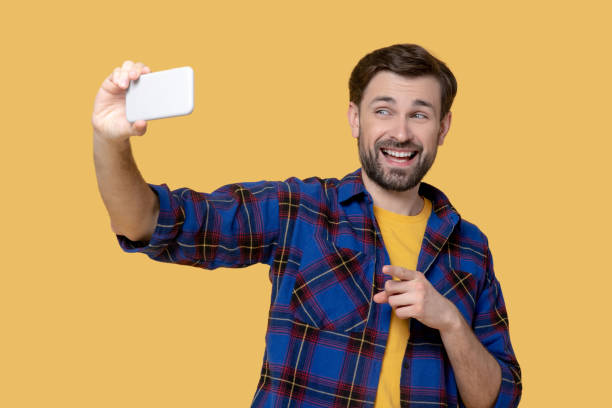 istock Cheerful grimacing man taking a selfie on a smartphone. 1239665586