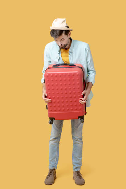 istock Sad man clutching a suitcase looking down 1239666707