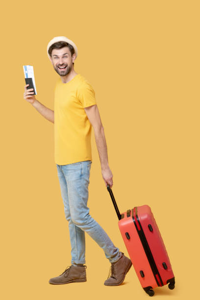istock Happy young bearded man with ticket and suitcase 1239666710