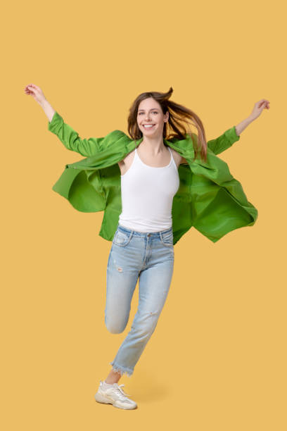 istock Joyful running girl in a jacket and sneakers 1239666713