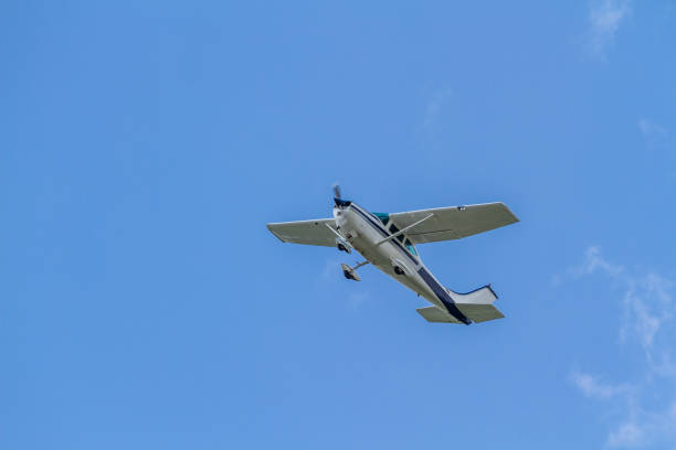 un petit avion léger vole dans un ciel bleu clair. orientation horizontale - pilot cockpit airplane training photos et images de collection