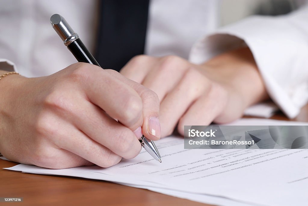 person's hand signing an important document Agreement Stock Photo