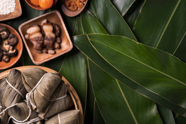 reisknödel, zongzi - traditionelle chinesische küche auf grünem blatt hintergrund von dragon boat festival, duanwu festival. - bamboo green frame sparse stock-fotos und bilder