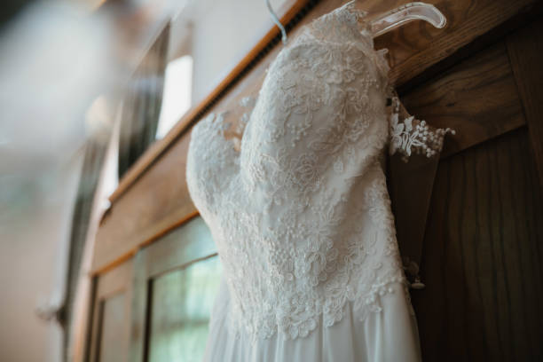 photo of a wedding dress hanged on a closet a wedding dress hanged on a closet wedding dresses stock pictures, royalty-free photos & images
