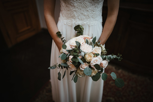 bride holds bridal bouquet with wild flowers