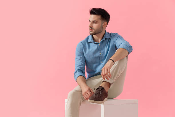 istock businessman sitting on cube and looking aside with attitude 1239725736