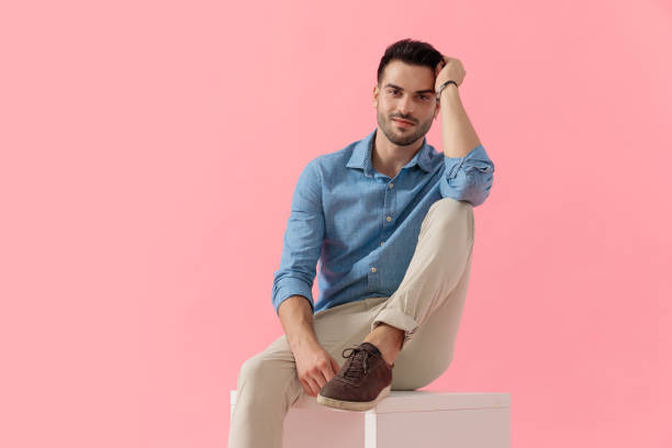 istock businessman with leg resting on cube and arm on knee 1239726245