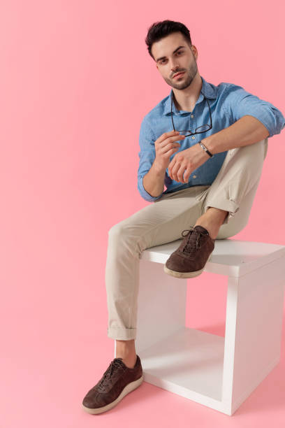 istock businessman taking off eyeglasses and looking at camera cool 1239728095