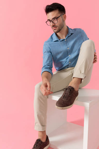 istock businessman sitting on cube and looking away serious 1239728950