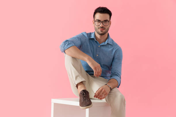 istock businessman sitting on cube and looking at camera happy 1239730059