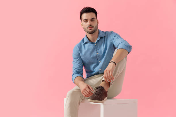 istock businessman sitting on cube and posing with cool attitude 1239730590