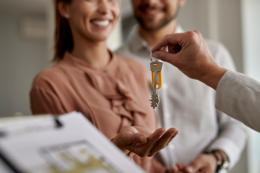 Primer plano de la pareja que recibe nuevas llaves de la casa de un agente de bienes raíces. photo