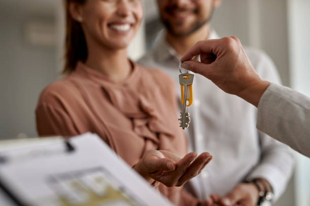 primer plano de la pareja que recibe nuevas llaves de la casa de un agente de bienes raíces. - piso residencia fotografías e imágenes de stock