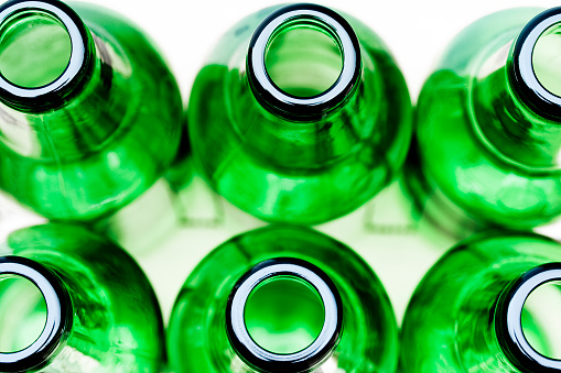 Some green glass bottles on a white background.