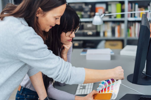 istock Two women choosing colors from color swatch fan 1239773449