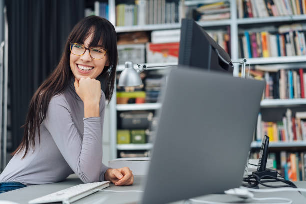 istock Happy businesswoman sitting at a computer 1239782293