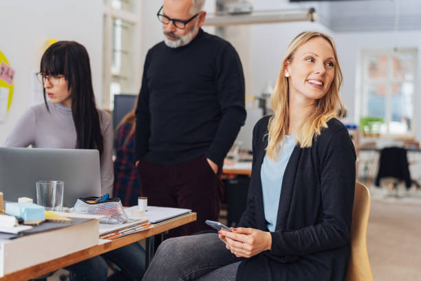 istock Smiling woman looking back. Office life scene 1239790441