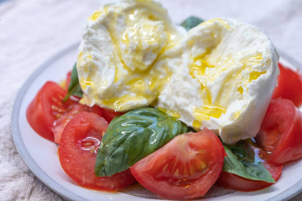 istock Ingredients for vegetarian caprese salad, buffalo mozzarella cheese, fresh basil, tomatoes, olive oil. Italian food served outdoor on terrace 1239793832