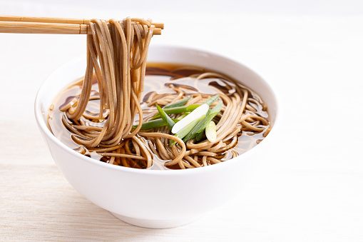 soba noodles, zaru soba, in white bowl with bamboo chopsticks