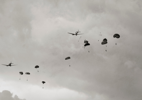 World War II era airplanes dropping paratroopers