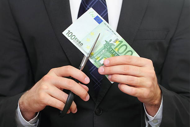 istock Man holding scissors cutting through a 100 Euro bill 123982837