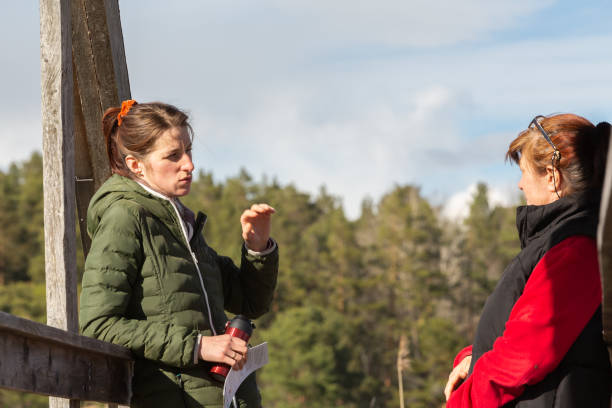 istock Two women are talking to each other while on a wooden bridge. 1239830891