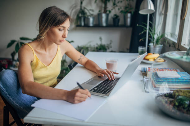 istock Beautiful woman using laptop in home office 1239836361