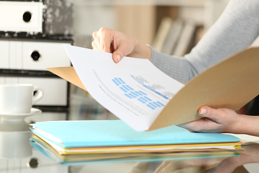 Woman hands checking documents on folders