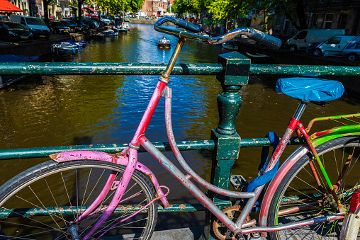 Amsterdam, Netherlands - September 7, 2018: Old multicolor vintage bicycle parked on a bridge on a canal in Amsterdam, Netherlands