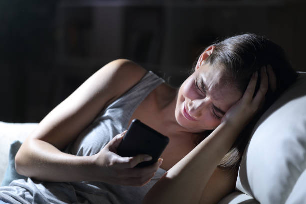 istock Sad woman complaining with phone at night at home 1239843929