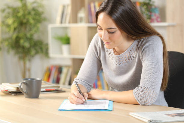 istock Woman filling out checkbox form at home 1239845526