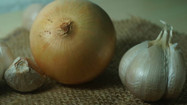 istock Organic onions and garlics on a brown jute cloth 1239846576