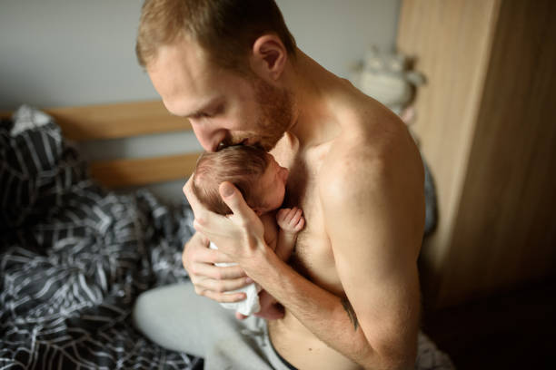 A father holds in his arms his newborn son. stock photo