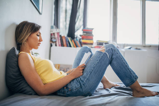 istock Beautiful woman reading a book in bed 1239846583