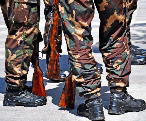 istock Soldiers standing outdoors with rifles 1239846606