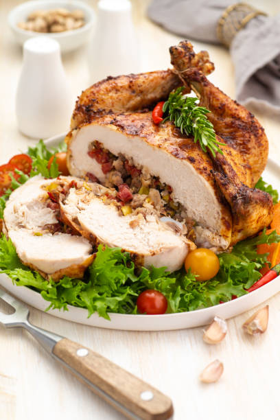 istock Stuffed boneless chicken garnished with fresh vegetables, lettuce, cherry tomatoes, bell peppers and fresh rosemary herbs. 1239847703