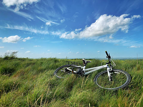 Beautiful view of agriculture field at the Ridgeway with a white mountain bike lying on ground.