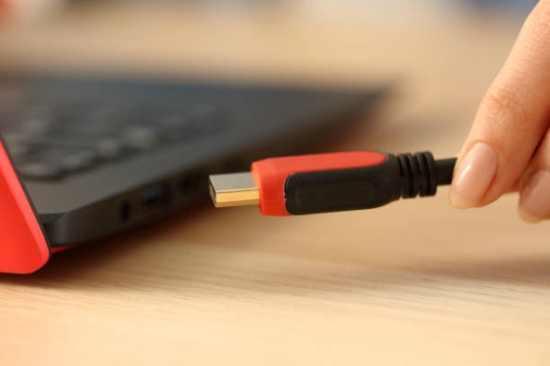 istock Woman hands plugging hdmi cable on laptop 1239851507