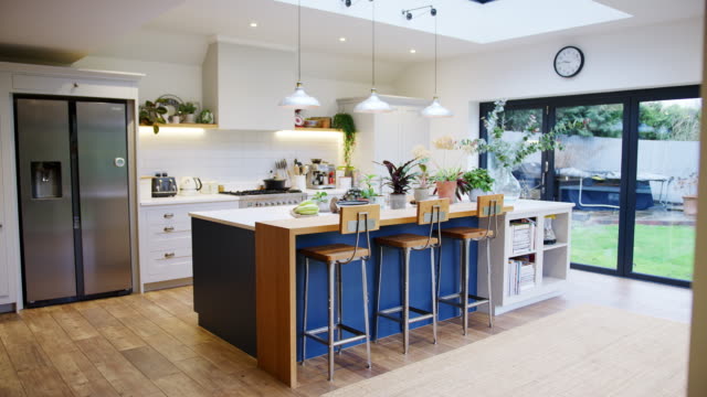 Interior view of beautiful kitchen with island counter and house plants in family home - shot in slow motion