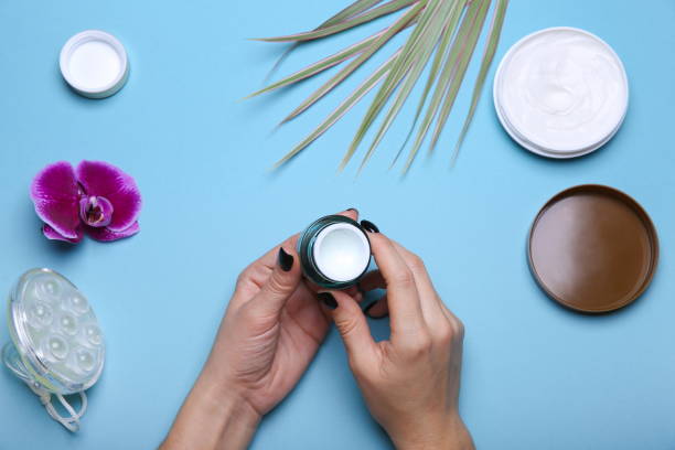 istock Woman's hands holding jar with cream over blue table 1239915831