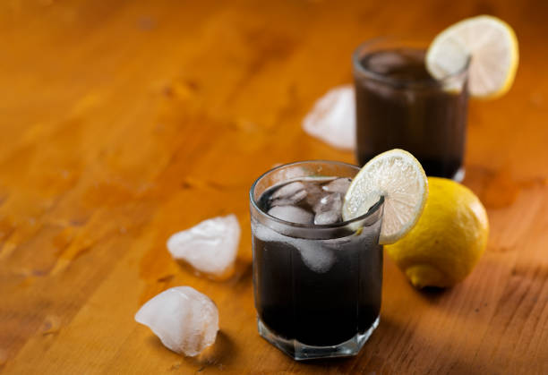 Cold detox lemonade with charcoal on a wooden table