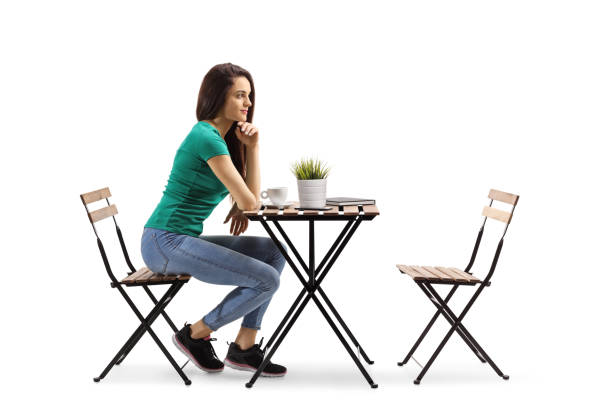 istock Young woman sitting at a wooden table and thinking 1239945086