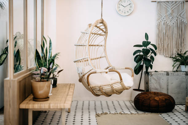 cadeira aconchegante pendurada na sala de estar loft com design elegante e bohemia. bem projetado e decorado com uma variedade de plantas interessantes - boho - fotografias e filmes do acervo