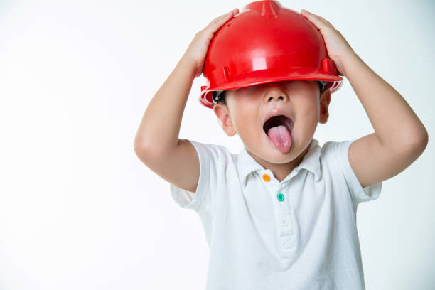 Little boy engineer with protective helmet against white background.