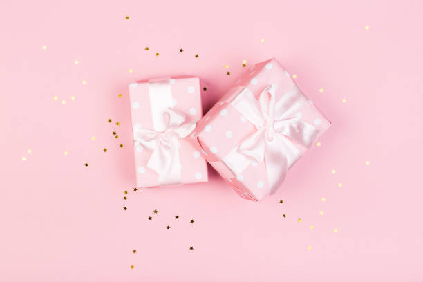 istock Gift or gift box and stars confetti on a pink table from above. Flat composition for birthday, mothers day or wedding. 1239969482