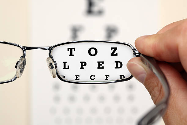 Eye test Looking through glasses at an eye exam chart eye exam stock pictures, royalty-free photos & images